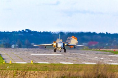 Sırtına paraşüt atarak iniş yapan bir savaş uçağı yavaşlar..