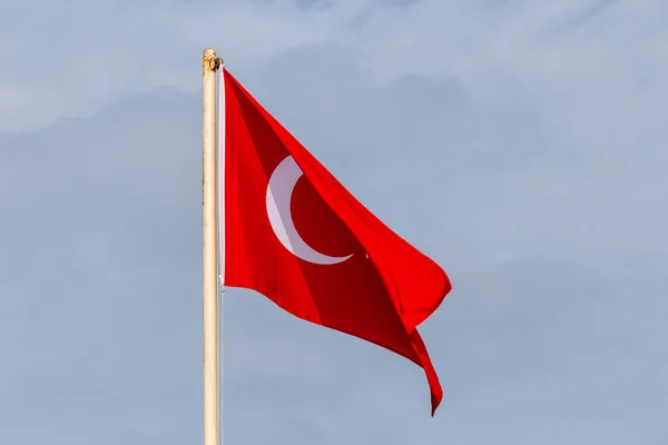 Flag of Turkey hanging out on a pole during windy day.