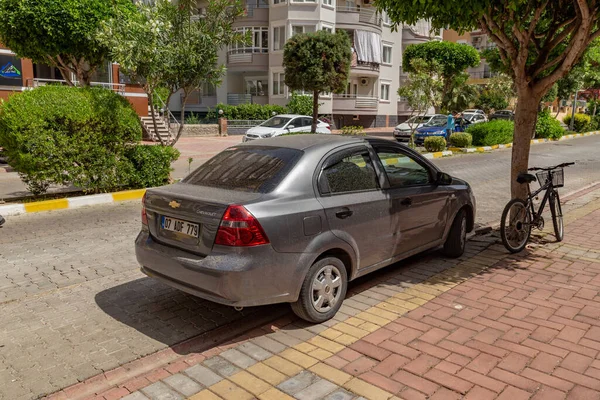 Alanya, Antalya, Türkiye - 05-25-2019: Sıcak yaz mevsimi nedeniyle bir ağacın gölgesine park edilmiş araba.