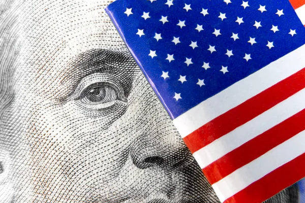 Amerika 'nın mikro bayrağının arkasında saklanan 100 dolarlık banknottan Benjamin Franklin' in aşırı makrosu. Gerçek fotoğraf..