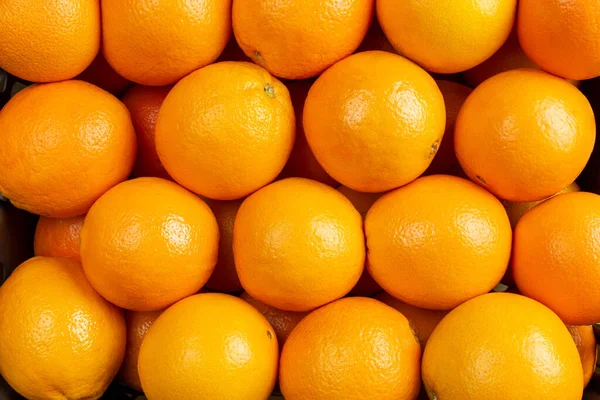 Oranges fruit background. Closeup on a heap of oranges stacked togather. Orange texture that can be used for everything.