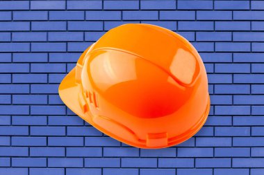 Mavi tuğlalı arka planda izole edilmiş koruyucu başlık. Zine endüstriyel kavramı.