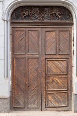 Eve giriş kapısı ve binanın ön cephesinde büyük metal süslemeler var..