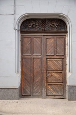 Eve giriş kapısı ve binanın ön cephesinde büyük metal süslemeler var..