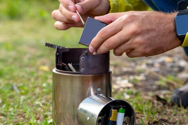 Tourist equipment and tools: camping stove burning out. Igniting with matches.