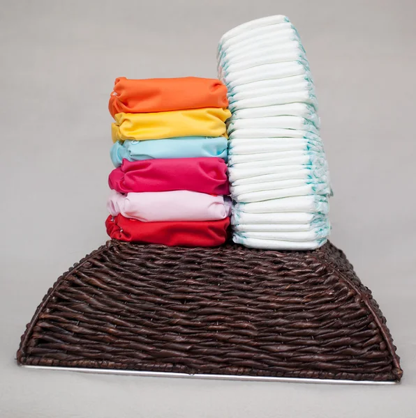 Stacks of disposable diapers and modern cloth diapers — Stock Photo, Image