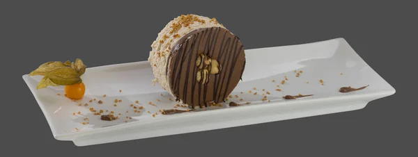 Kulatý čokoládový dezert s oříšky na talíři izolované na šedé — Stock fotografie