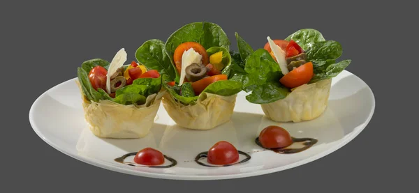 Salad of spinach, olives and tomato with baked dough — Stock Photo, Image