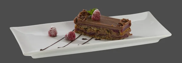 Bolo de chocolate com framboesas em uma placa isolada em uma ba cinza — Fotografia de Stock