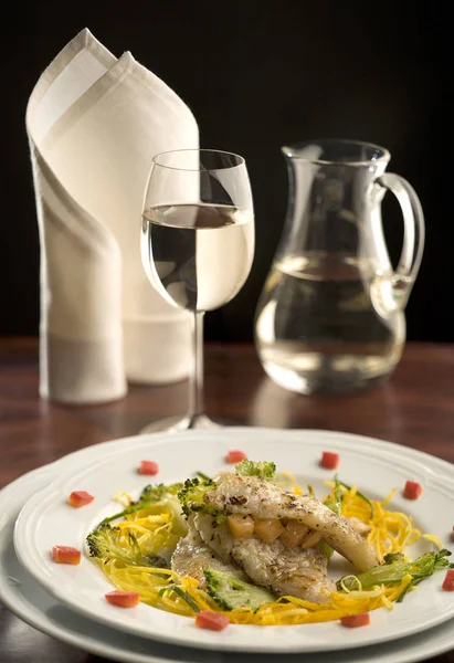 Beautiful table with a plate of grilled fish and a glass of whit — Stock Photo, Image