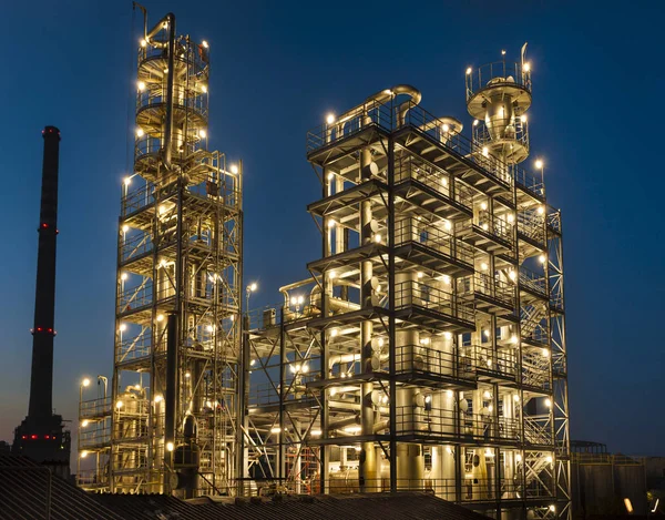 Vista general de una refinería de petróleo iluminada por la noche, tuberías Imagen de stock