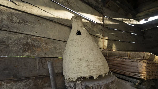 Interior de un antiguo granero rústico de madera con una colmena de abejas silvestres, canasta y tablas viejas — Foto de Stock