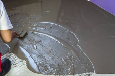 Ev yapım aşamasında. İşçinin üzerine şap tesviye kendini koyar 