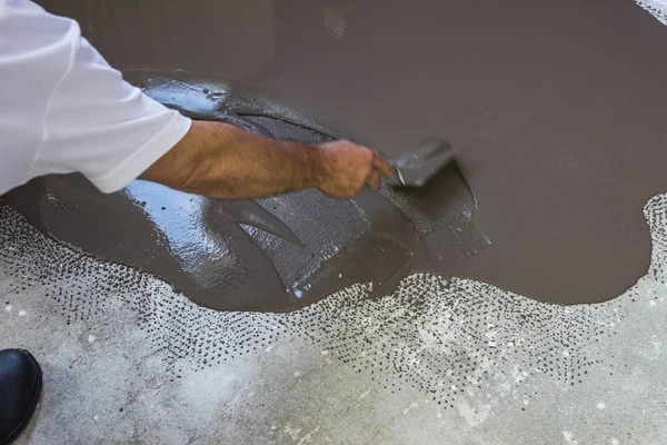 Werknemer stelt een herverdeling van de dekvloer op cement vloer zelf. Appartement VN — Stockfoto