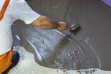 Öz mala üzerinde çimento ile şap tesviye bir işçi koyar ben kat