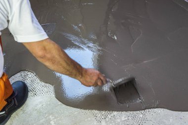 İşçinin çimento zemin daire şap tesviye kendini koyar