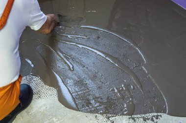 Öz mala üzerinde çimento ile şap tesviye bir işçi koyar ben kat