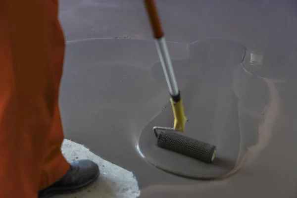 Vloerbekleding met zelf cement mortel herverdeling. Roller applicat — Stockfoto