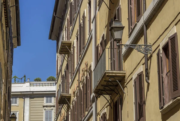 Elegant street lantern of wrought iron and a glass lampshade on