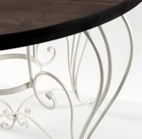 Wrought iron. Beautiful curved ornaments of table with wooden to — Stock Photo, Image