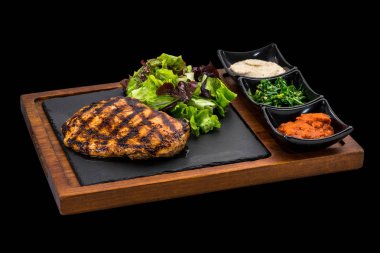 kavrulmuş tavuk biftek soslar ve yeşil salata ile süslenmiş bir