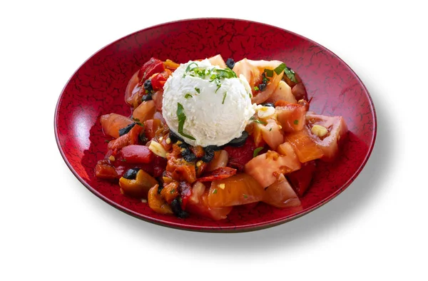 Свежий салат со сливочным сыром и помидорами в современной красной тарелке — стоковое фото