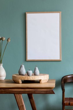 Şık ve minimalist yemek odası. Poster çerçevesi, ahşap masa, vazoda çiçekler, meyve tepsisi ve zarif aksesuarlar. Okaliptüs rengi. Kullanmaya hazır. Şablon. Modern ev dekorasyonu.