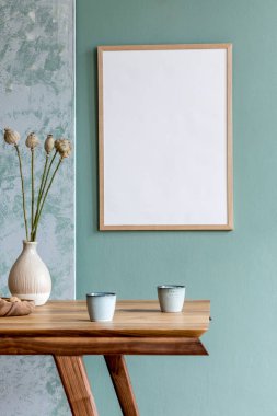 Şık bir İskandinav yemek odası. Poster çerçevesi, ahşap masa, mobilya, kahve fincanları, vazodaki çiçekler ve zarif aksesuarlarla süslenmiş. Kullanmaya hazır. Şablon. Modern ev dekorasyonu.