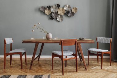 Modern ve şık yemek odaları, göz alıcı ahşap masa, zarif sandalyeler ve tasarım dekorasyonu. Şablon. Ev dekoru. Gri arka plan duvarı. İç tasarımın minimalist kavramı.