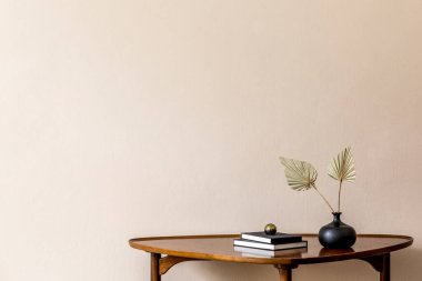 Tasarım masasında kitaplar ve vazoda kağıt çiçeklerle süslü bir kompozisyon. Bej arka plan duvarları. Oturma odasının minimalist konsepti. Uzayı kopyala Şablon. 