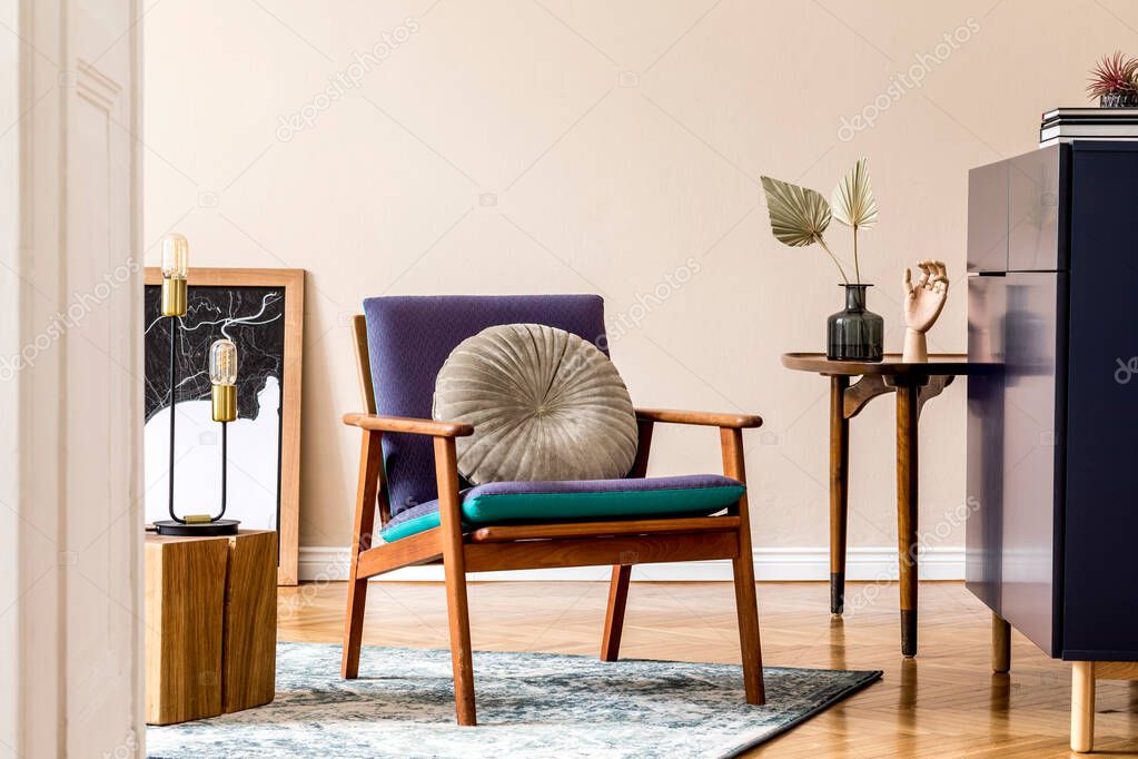 Interior design of retro modern living room with poster frames, blue navy commode, design armchair, cube, paper leafs, books, lamp and elegant personal accessories. Stylish home decor. Template.