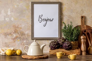Ahşap masa, kahverengi fotoğraf çerçevesi, limonlar, sebzeler, çaydanlık, fincanlar ve mutfak aksesuarları Wabi Sabi ev dekorasyonu kavramında.. 