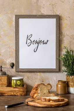 Mutfağın içinde ahşap masa, kahverengi fotoğraf çerçevesi, sebze, kavanoz, şifalı otlar ve mutfak aksesuarları Wabi Sabi ev dekorasyonu kavramında.. 