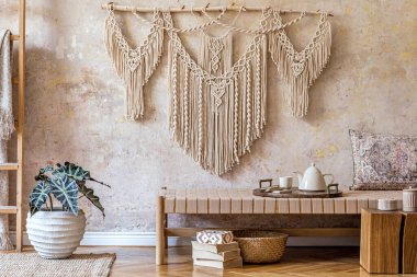 Tasarım bej şezlongu, güzel makromu, yastığı, ahşap tepsisi, halısı ve Wabi Sabi ev dekorunda özel aksesuarları olan şık bir doğu oturma odası..