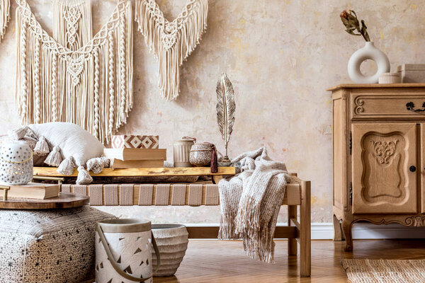 Stylish oriental living room with design beige chaise longue, beautiful macrame, pillows, wooden tray, carpet and elegant personal accessories in wabi sabi home decor.