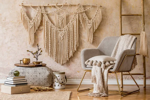 Modern koltuk, makrome, ahşap merdiven, yastıklar, dekorasyonlar ve şık ev dekorları ile doğu oturma odasının iç tasarımı. Wabi sabi duvarı.