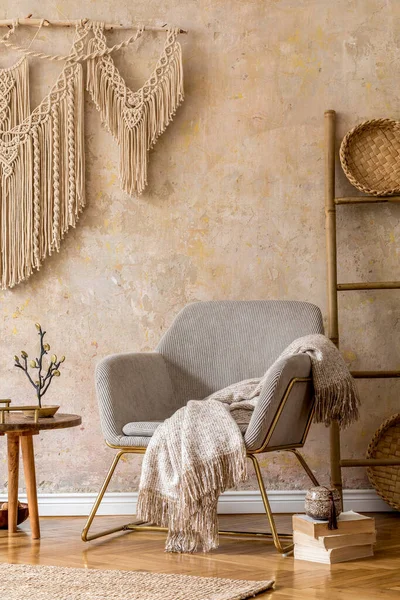 stock image Interior design of oriental living room with modern armchair, macrame, wooden ladder, plaid, decorations and elegant personal accessories in stylish home decor. Wabi sabi wall.