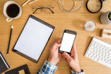 Tablet ekranı, ofis malzemeleri, kaktüs, telefon, notlar, bitkiler ve özel aksesuarlar kullanan işadamlarının şık ofis kompozisyonu.