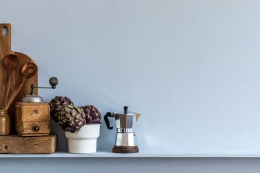 Mutfağın iç kısımlarında sebzeler, kesim tahtası, kahve süzgeci, mutfak aksesuarları ve raflarda fotokopi alanı var..