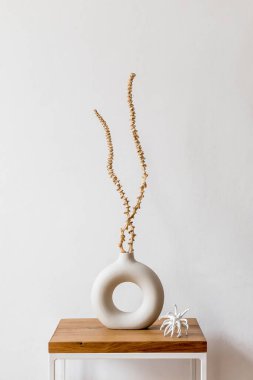 Modern ev dekorunda, içinde şık kurutulmuş çiçekler, ahşap merdiven ve kişisel aksesuarlar olan oturma odasının iç tasarımı..