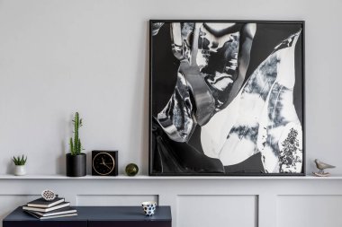 Şık lacivert klozet, kitap, siyah saat, kaktüs, modern tablolar, dekorasyon ve ev dekorasyonunda zarif aksesuarları olan oturma odasının iç tasarımı.