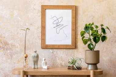 Modern oturma odasının tasarım ahşap konsolu, bitkiler, kahverengi poster çerçevesi, dekorasyonu ve Wabi Sabi ev dekorasyonundaki zarif kişisel aksesuarları..