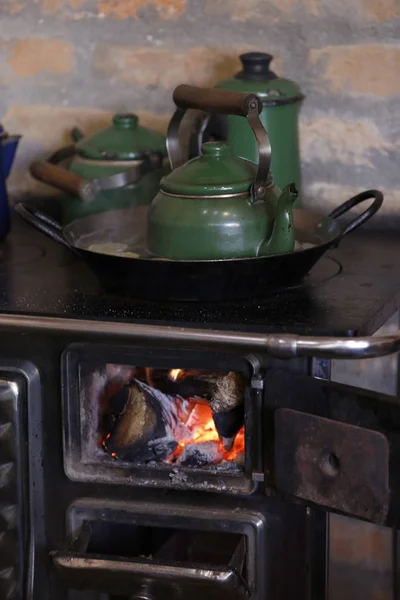 warm fire heating a coffee kettle in wood burning stove. Traditional style in countryside of Brazil