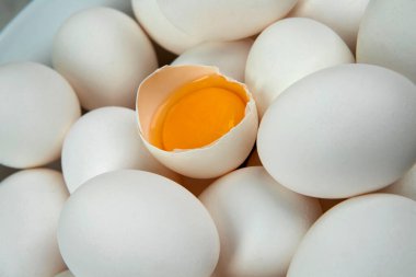 Yumurtanın sarısını gösteren beyaz tavuk yumurtaları.