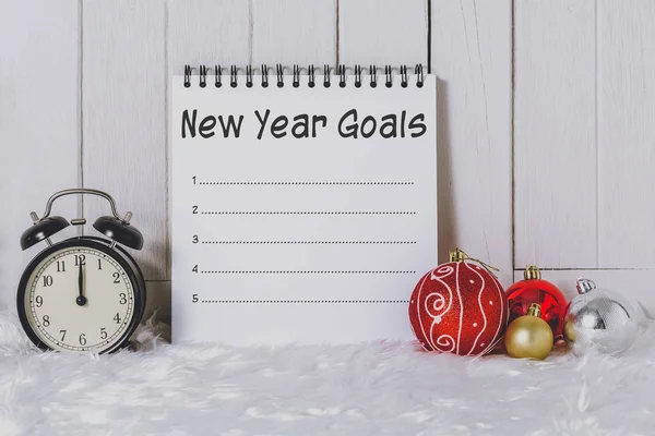 Alarm clock with Christmas ornaments and New Year's Goals List w — Stock Photo, Image