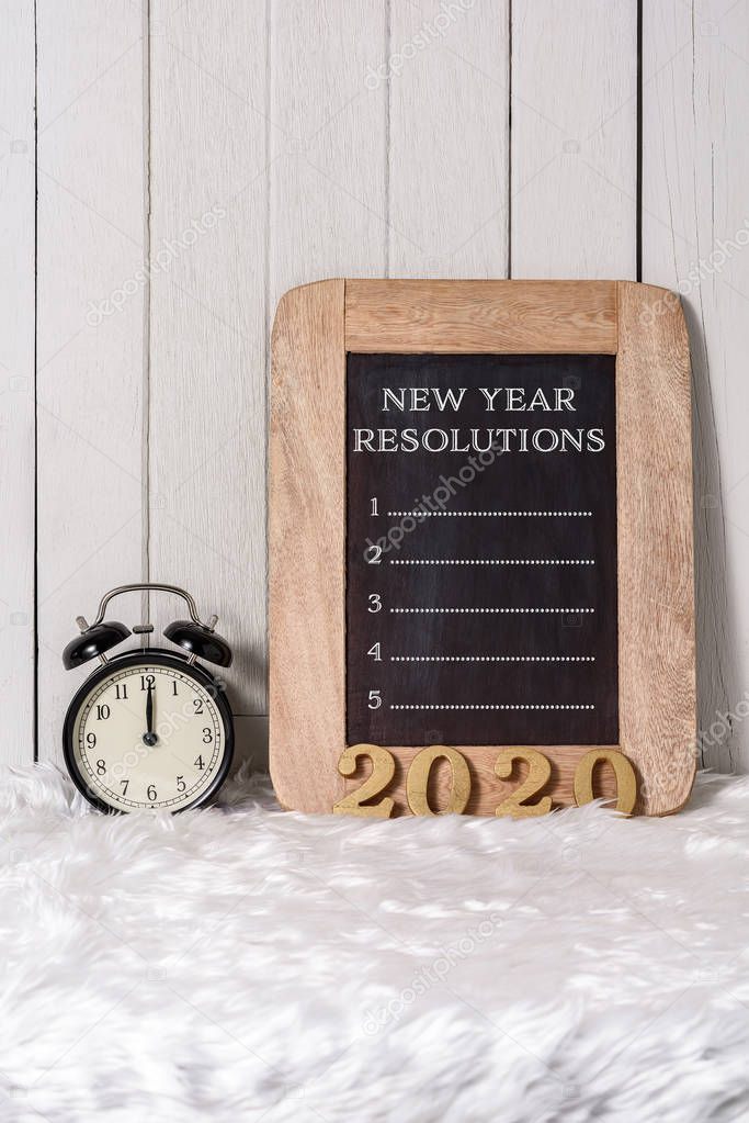 2020 wooden text and New Year's Resolutions List written on Note