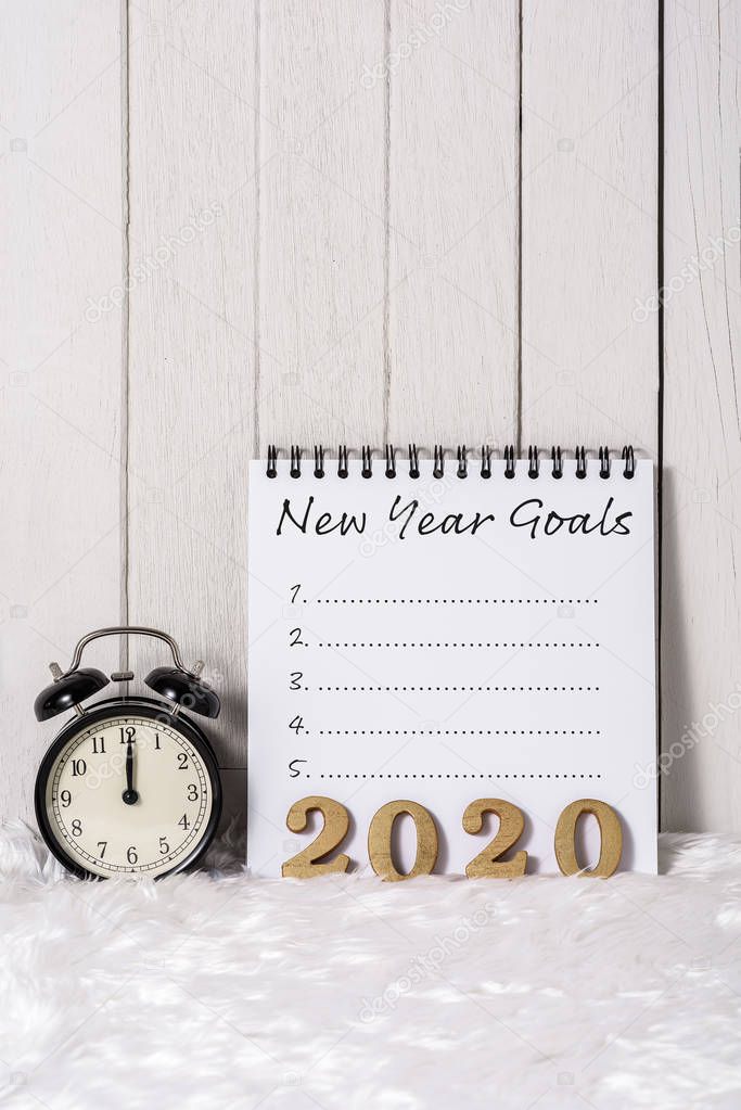 2020 wooden text and New Year's Goals List written on Notebook w