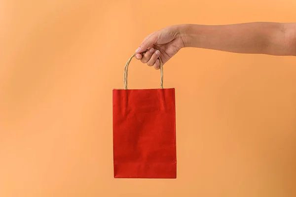 Žena ruka drží červené papaer nákupní tašky — Stock fotografie