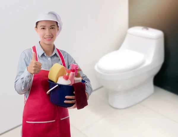 Vrouw met emmer klaar om schoon te maken huis op toilet achtergrond terug — Stockfoto