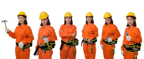 建筑施工女工穿着橙色防护服 头戴头盔 手持工具 带工具带 白色背景隔离 免版税图库图片